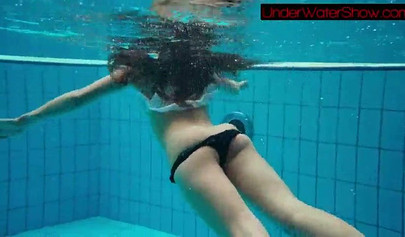 Gorgeous teen strips naked while swimming in the pool