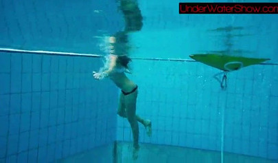 Gorgeous teen strips naked while swimming in the pool