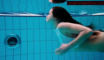 Gorgeous teen strips naked while swimming in the pool