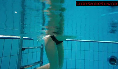 Gorgeous teen strips naked while swimming in the pool