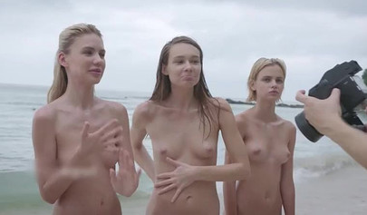 Four petite teens stripping and posing nude on the sandy beach